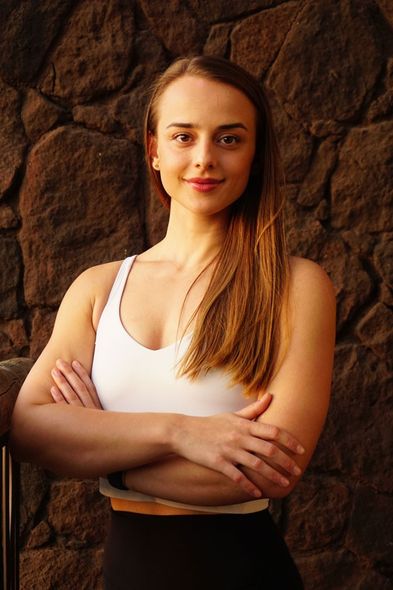 Lili Nowicki mit verschränkten Armen vor einer Steinwand